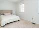 Simple bedroom with a white bed and a window for natural light at 3125 Morningside Dr, Raleigh, NC 27607