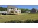 New construction two-story home featuring unfinished porch and spacious grassy backyard with green tree backdrop at 317 Hampshire Court, Four Oaks, NC 27524