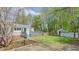 Large backyard with a wooden deck, mature trees, and garden beds at 322 W Hill N Ave, Hillsborough, NC 27278