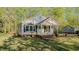 A charming exterior showcases a well-maintained lawn and landscaping with beautiful flowering shrubbery near the front porch at 322 W Hill N Ave, Hillsborough, NC 27278