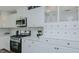 Close-up of a well-equipped kitchen with modern appliances, white cabinets, and sleek countertops for culinary enthusiasts at 322 W Hill N Ave, Hillsborough, NC 27278