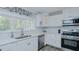 Well-lit kitchen offering modern appliances, white countertops, and ample cabinet space for efficient food preparation at 322 W Hill N Ave, Hillsborough, NC 27278