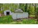 Backyard featuring a pair of weathered, vintage sheds with 'Welcome to the Farm' signage, adding rustic charm at 322 W Hill N Ave, Hillsborough, NC 27278