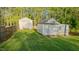 View of two white, charming outbuildings in the spacious backyard at 322 W Hill N Ave, Hillsborough, NC 27278