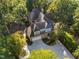 Stunning aerial view of a luxurious home nestled among mature trees, showcasing its architectural design and manicured grounds at 32430 Archdale, Chapel Hill, NC 27517
