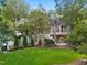 Expansive backyard with a well-manicured lawn, mature trees, patio, and rear elevation of the home at 32430 Archdale, Chapel Hill, NC 27517
