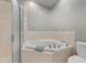 Well-lit bathroom featuring a corner bathtub, shower, and toilet at 32430 Archdale, Chapel Hill, NC 27517
