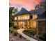 Stunning stone and shingle home featuring a covered porch, manicured landscaping, and a serene walkway under a beautiful sky at 32430 Archdale, Chapel Hill, NC 27517