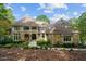 Beautiful stone and shingle home featuring a covered porch, manicured landscaping, and a stone walkway under a clear sky at 32430 Archdale, Chapel Hill, NC 27517