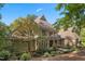 Beautiful stone and shingle home featuring a covered porch, manicured landscaping, and a stone walkway under a clear sky at 32430 Archdale, Chapel Hill, NC 27517