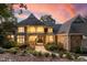 Beautiful stone and shingle home featuring a covered porch, manicured landscaping, and a stone walkway under a colorful sky at 32430 Archdale, Chapel Hill, NC 27517