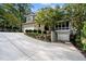 Beautiful house exterior featuring a multi-car driveway, garage, stone retaining wall, and lush landscaping at 32430 Archdale, Chapel Hill, NC 27517