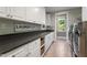 Well-appointed laundry room with ample counter space, white cabinets, and modern appliances for efficient chores at 32430 Archdale, Chapel Hill, NC 27517