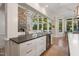 View from kitchen island to a cozy living room with stone fireplace and large windows with natural light at 32430 Archdale, Chapel Hill, NC 27517