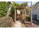 Backyard wooden gate with stone path surrounded by manicured shrubs at 379 Tobacco Farm Way, Chapel Hill, NC 27516