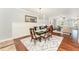 Elegant dining room featuring a modern chandelier, glass-top table with seating, and seamless flow to the living area at 379 Tobacco Farm Way, Chapel Hill, NC 27516