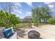 Landscaped backyard features a paved patio, a fire pit, manicured lawn, and mature trees at 411 Lawton Dr, Haw River, NC 27258