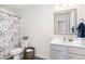Well-appointed bathroom with stylish floral shower curtain and classic vanity with modern mirror at 411 Lawton Dr, Haw River, NC 27258