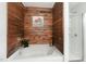 A stand-alone bathtub with wood-paneled walls, a shower, and a painting of cows at 411 Lawton Dr, Haw River, NC 27258