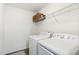 Bright laundry room features white appliances, wire shelving, and decorative woven baskets at 411 Lawton Dr, Haw River, NC 27258