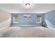 Spacious bedroom with neutral carpet, a light blue accent wall, and dual windows at 4228 Nc 42 Hwy, Raleigh, NC 27603