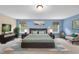 Staged main bedroom with blue accent wall, carpet, king bed, two windows, and decorations at 4228 Nc 42 Hwy, Raleigh, NC 27603