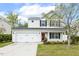 Charming two-story home featuring a two-car garage, red front door, and a well-manicured lawn with landscaping at 4817 Quarryman Rd, Raleigh, NC 27610