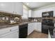 A kitchen showing white cabinets, black appliances, and a tiled backsplash, showcasing modern amenities at 4817 Quarryman Rd, Raleigh, NC 27610