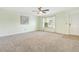 Bright living room with neutral carpet, a ceiling fan, and a large window offering natural light at 4817 Quarryman Rd, Raleigh, NC 27610
