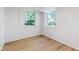 Basement room featuring two windows, white walls, and light wood-look vinyl flooring at 4902 Brookhaven Dr, Raleigh, NC 27612