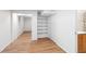 Finished basement hallway with shelves, closet, storage cabinet and wood-look floors at 4902 Brookhaven Dr, Raleigh, NC 27612