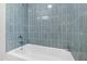 Bathroom featuring light blue wall tile and a white porcelain tub at 4902 Brookhaven Dr, Raleigh, NC 27612