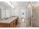 Bathroom showcasing a double vanity, large mirror, and walk-in shower at 4902 Brookhaven Dr, Raleigh, NC 27612