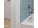Close up of bathroom with blue tiles, shower head and bathtub at 4902 Brookhaven Dr, Raleigh, NC 27612