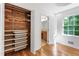 Walk-in closet featuring custom shelving, wood flooring, and adjacent bathroom at 4902 Brookhaven Dr, Raleigh, NC 27612