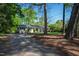 View of the home's exterior nestled among mature trees and natural landscaping at 4902 Brookhaven Dr, Raleigh, NC 27612