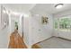 Well-lit hallway with hardwood floors and white walls, leading to bedrooms and living areas at 4902 Brookhaven Dr, Raleigh, NC 27612