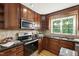 Modern kitchen featuring dark wood cabinetry, granite countertops, and stainless steel appliances at 4902 Brookhaven Dr, Raleigh, NC 27612