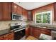 Updated kitchen features granite countertops, a view of the backyard, and modern stainless steel appliances at 4902 Brookhaven Dr, Raleigh, NC 27612