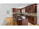 Kitchen featuring dark wood cabinets, granite counters, stainless appliances, and hardwood floors at 4902 Brookhaven Dr, Raleigh, NC 27612