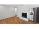 Cozy living area with white brick fireplace, open shelving, and stainless steel refrigerator at 4902 Brookhaven Dr, Raleigh, NC 27612