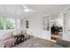 Bright sunroom with tile flooring, white painted brick, and access to other rooms at 4902 Brookhaven Dr, Raleigh, NC 27612