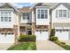 Charming townhome exterior with stone accents, attached garage, and a neatly landscaped front yard at 4924 Amber Clay Ln, Raleigh, NC 27612