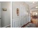 Hallway leading to a dining area and living room, with hardwood floors and elegant wainscoting at 4924 Amber Clay Ln, Raleigh, NC 27612