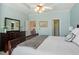 Main bedroom featuring blue walls, ceiling fan, large bed, and large window at 4924 Amber Clay Ln, Raleigh, NC 27612