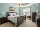 Main bedroom featuring blue walls, ceiling fan, large bed, and large window at 4924 Amber Clay Ln, Raleigh, NC 27612