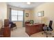 Well-lit home office features a large wood desk, comfortable seating, and neutral colored walls at 4924 Amber Clay Ln, Raleigh, NC 27612