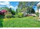 Lush backyard featuring mature trees, green grass and a storage shed at 5016 Silhouette Dr, Durham, NC 27713