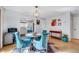 Dining room with hardwood floors, a round table and four blue chairs, and colorful wall decor at 5016 Silhouette Dr, Durham, NC 27713