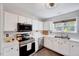 Modern kitchen with white cabinetry, stainless steel appliances, and a bright window above the sink at 5016 Silhouette Dr, Durham, NC 27713